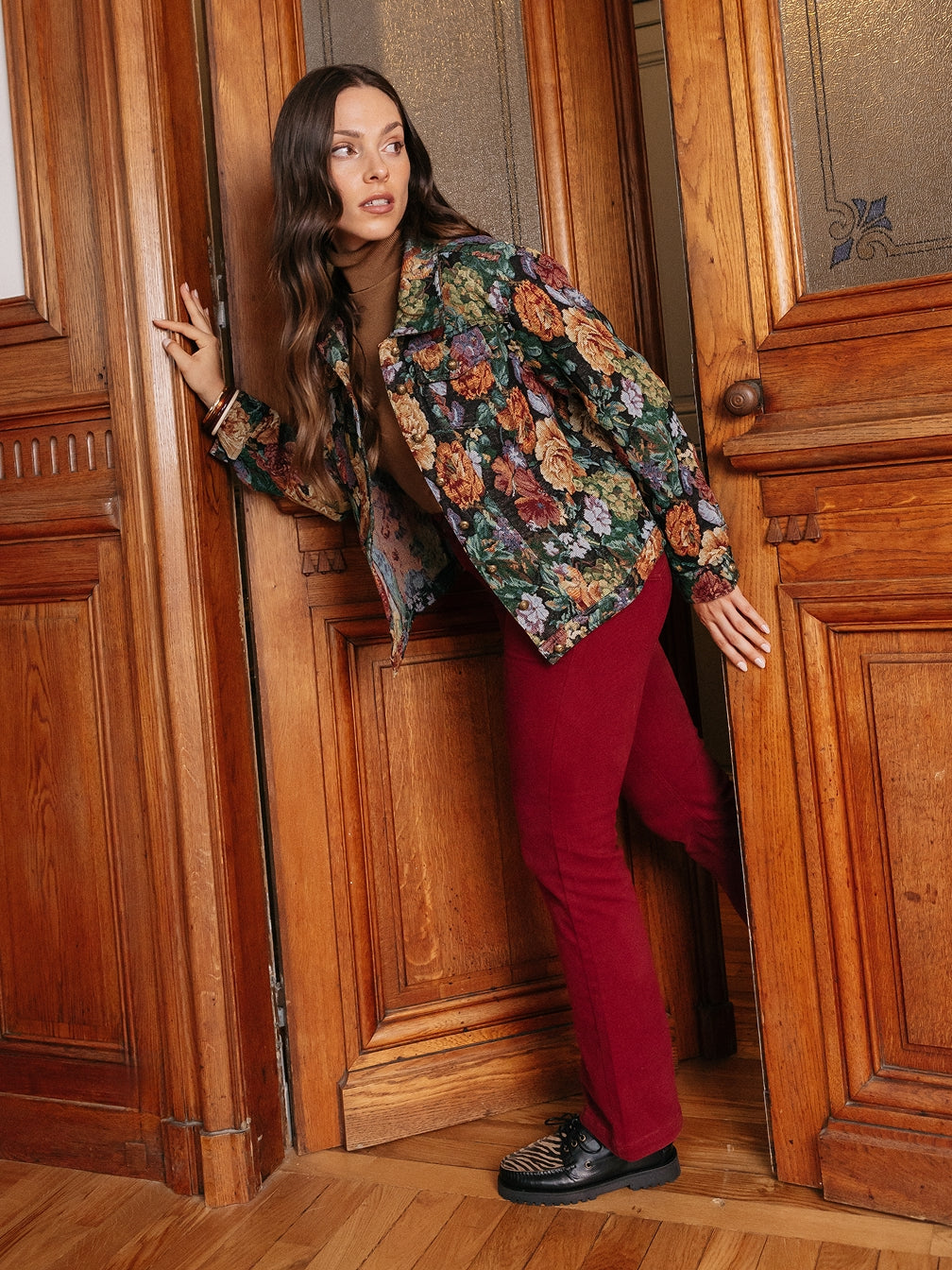 Femme en veste fleurie et pantalon bordeaux portant des mocassins noirs – KOST