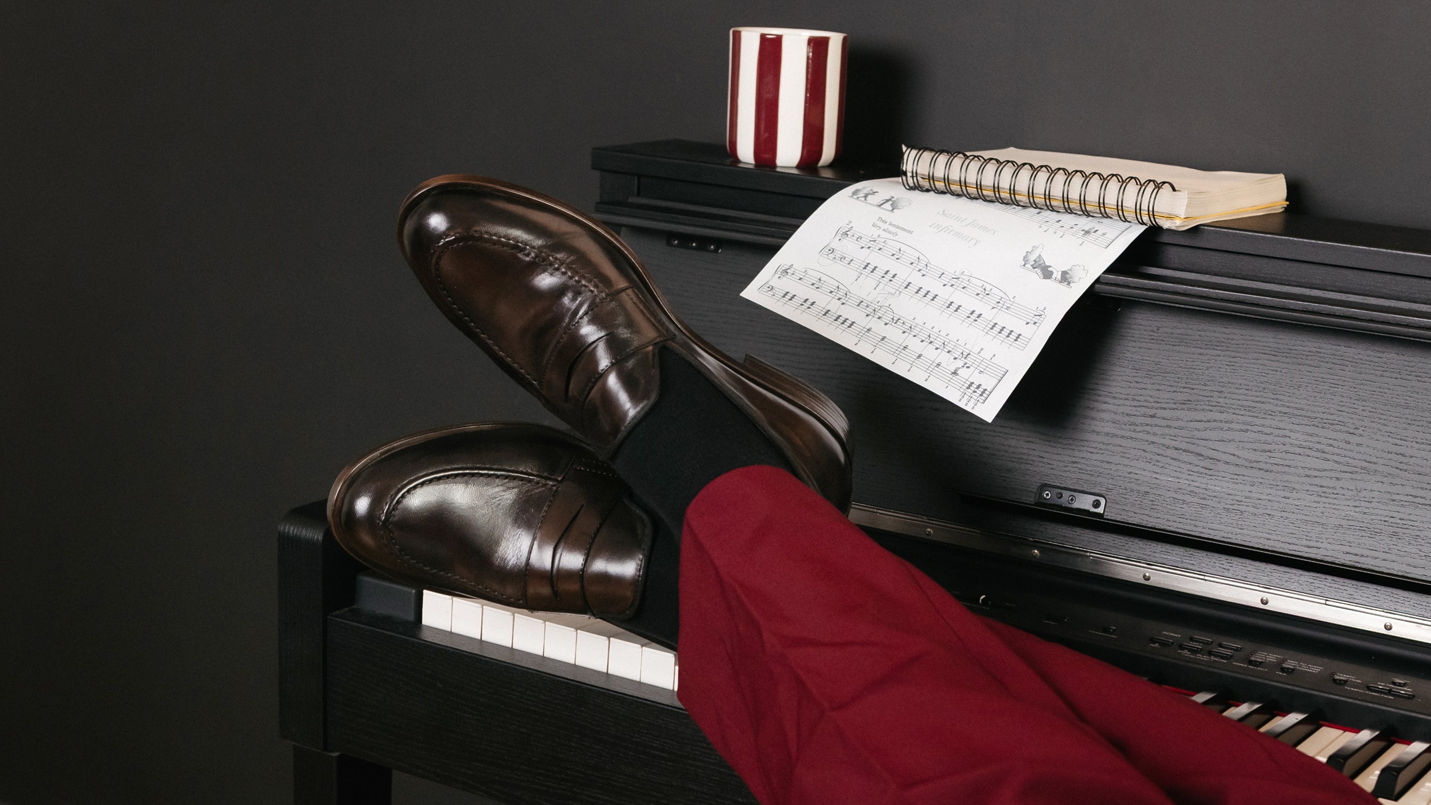Mocassins homme en cuir marron foncé posés sur un piano – STEP KOST